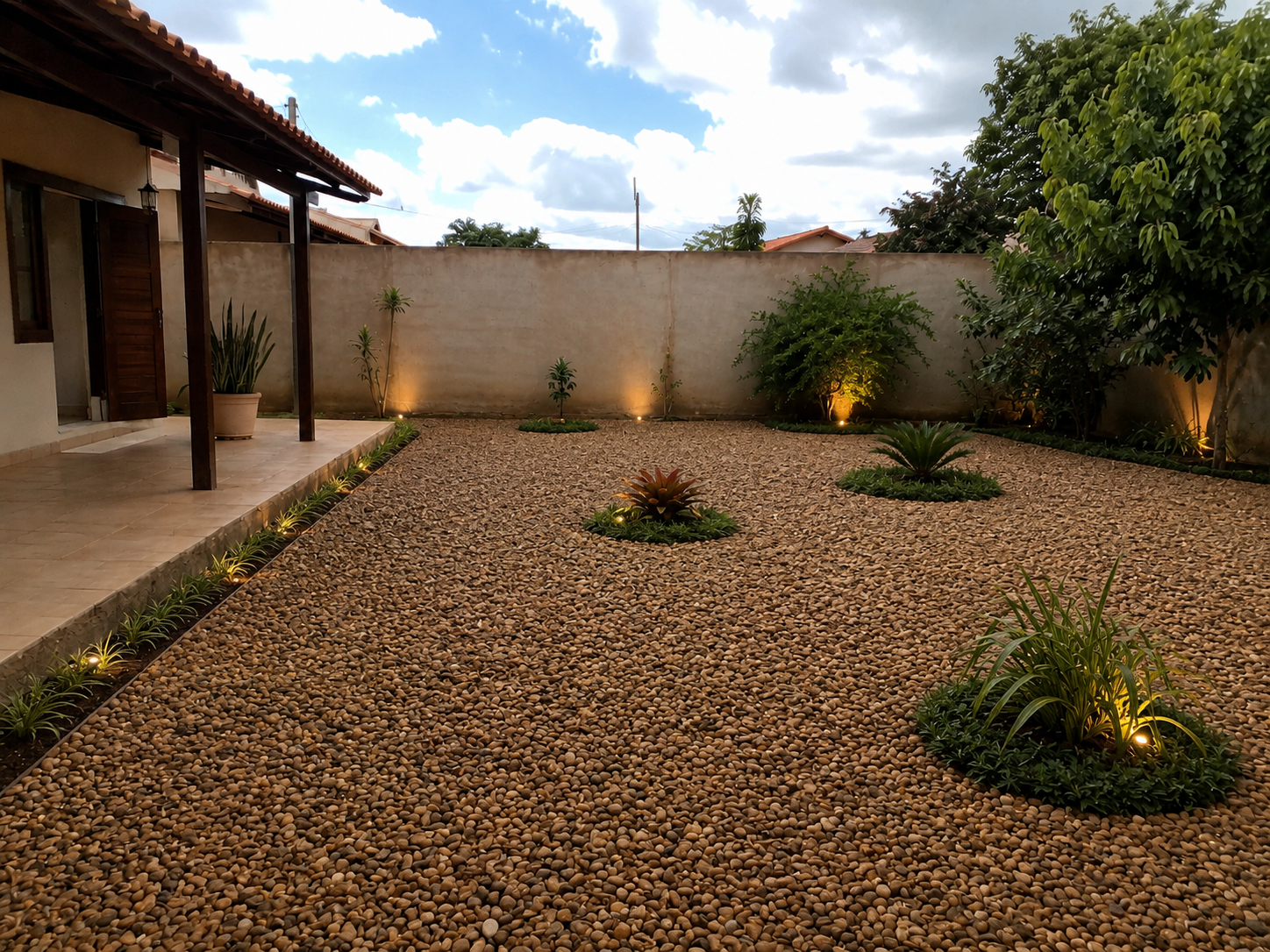 Mesmo quintal transformado com Seixo Marrom Natural, iluminação e paisagismo